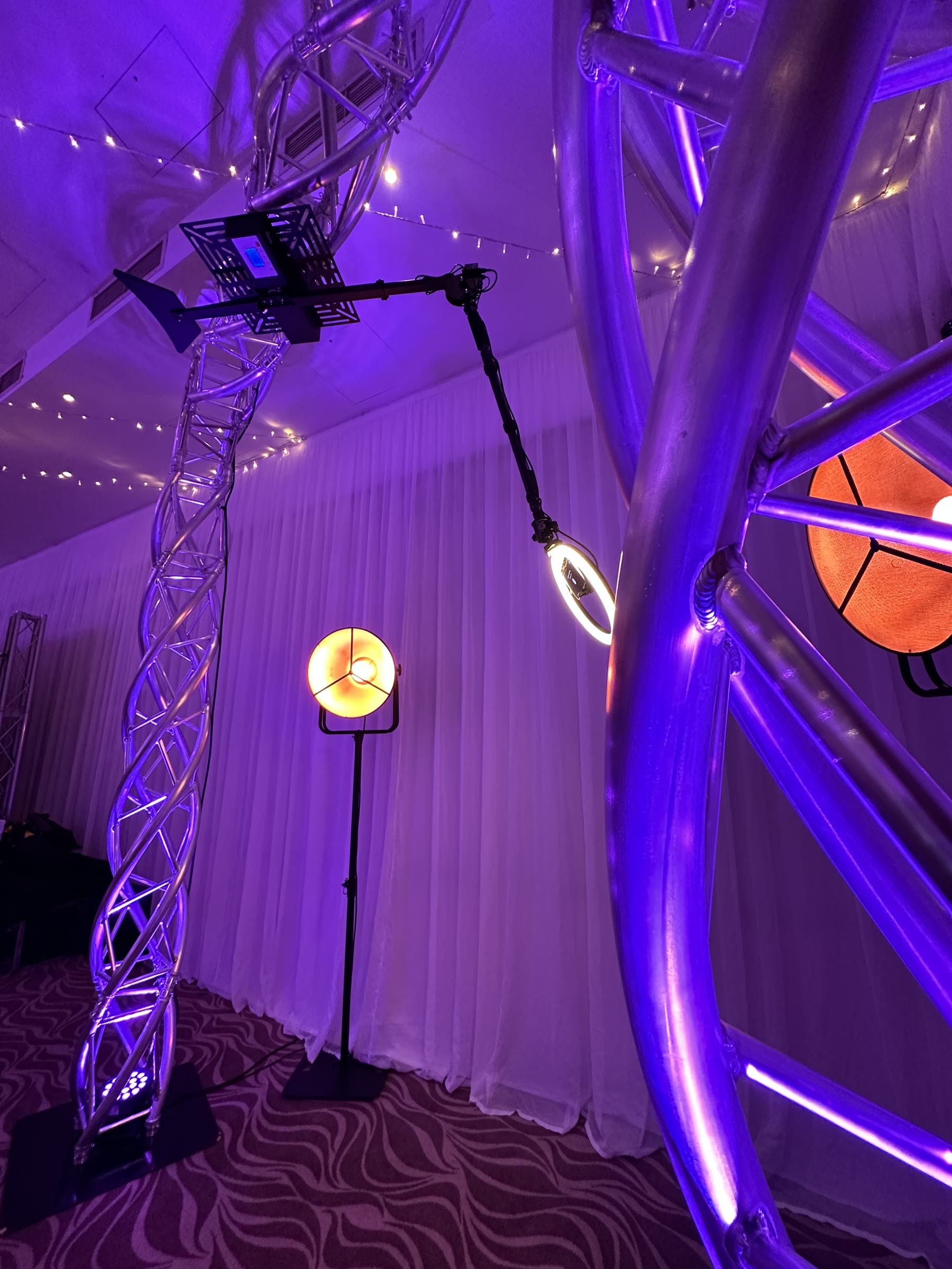 Detailed view of a 360 degree video booth camera arm inside an illuminated truss structure
