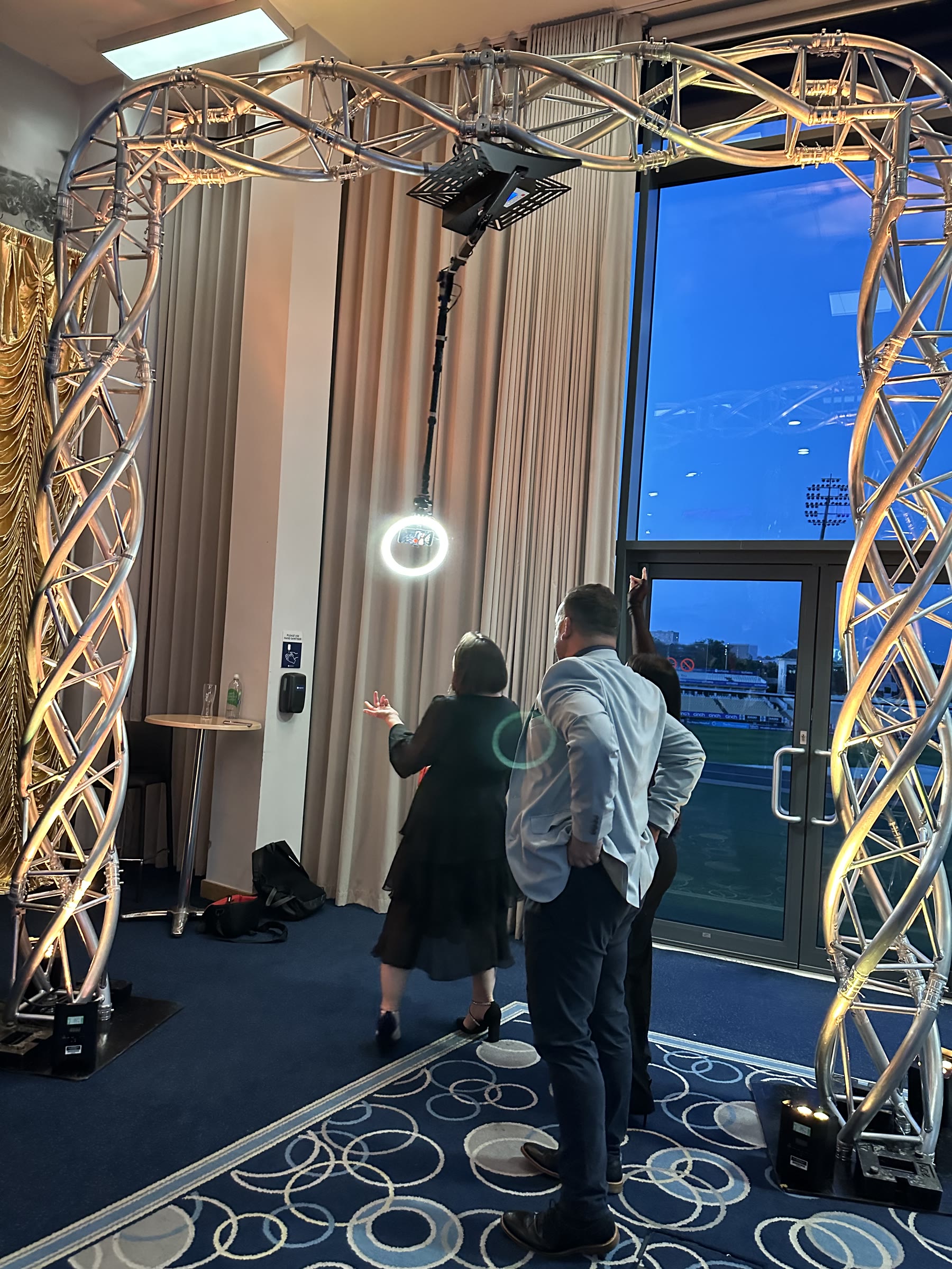 Guests using a 360 degree video booth at a corporate venue overlooking a sports ground