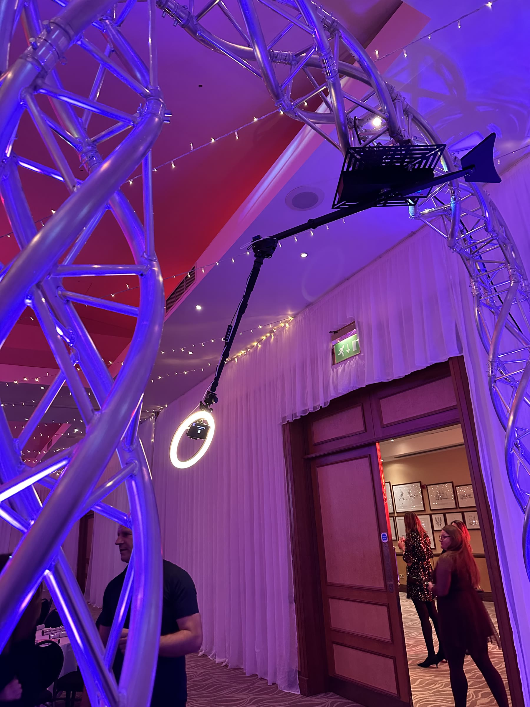 Purple lit curved truss and rotating camera arm at a 360 degree video booth event