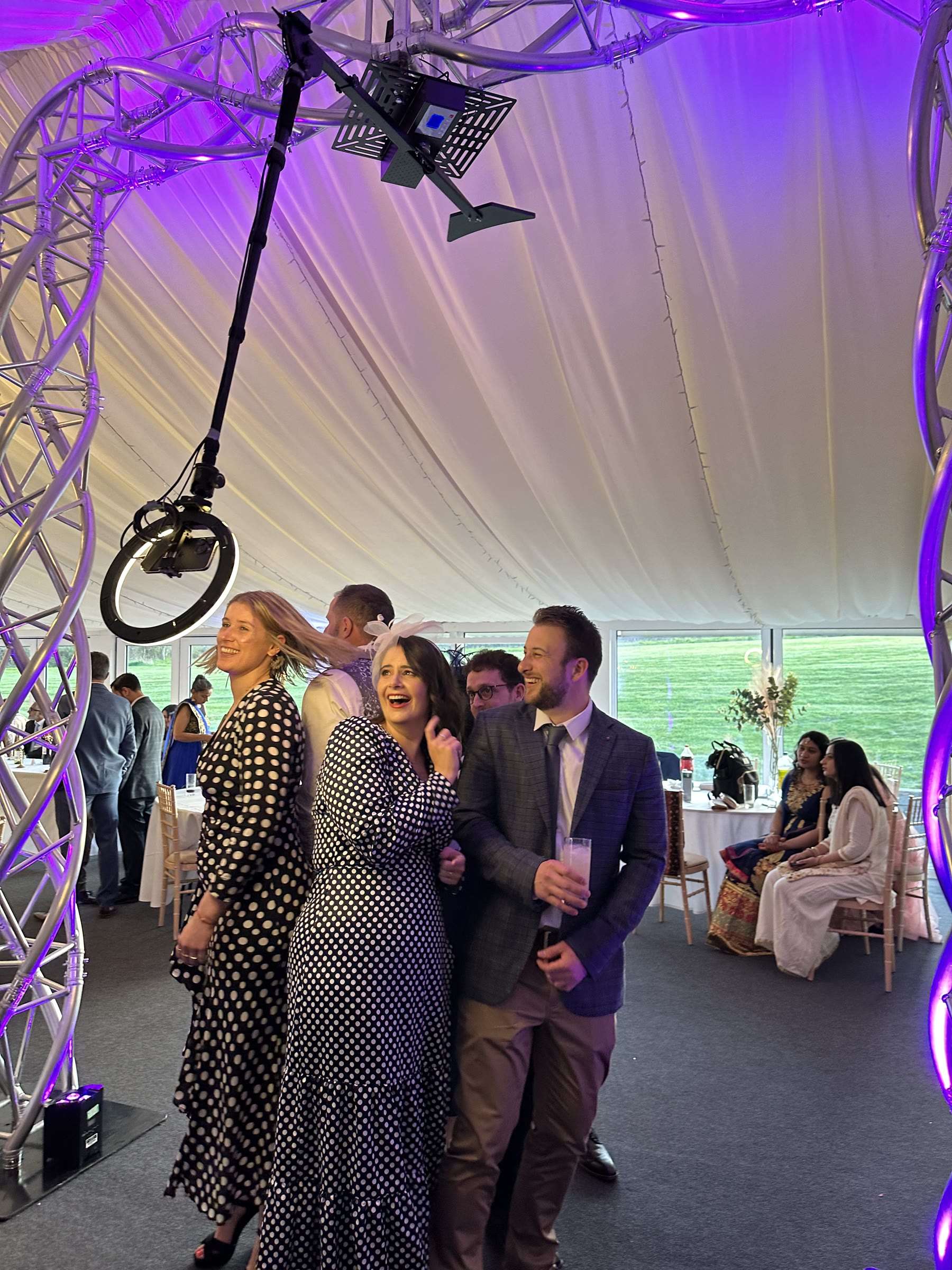 Smiling wedding guests creating a 360 degree rotating video at a reception