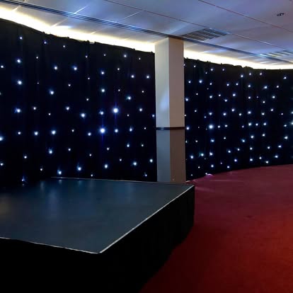 Black starcloth backdrop behind a stage