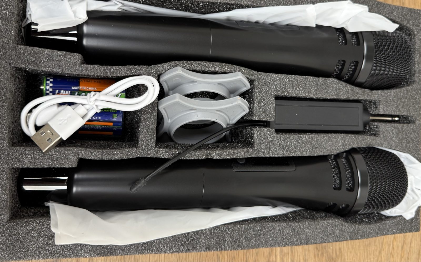 Two wireless handheld microphones, plug-in receiver, USB cable and accessories in fitted packaging