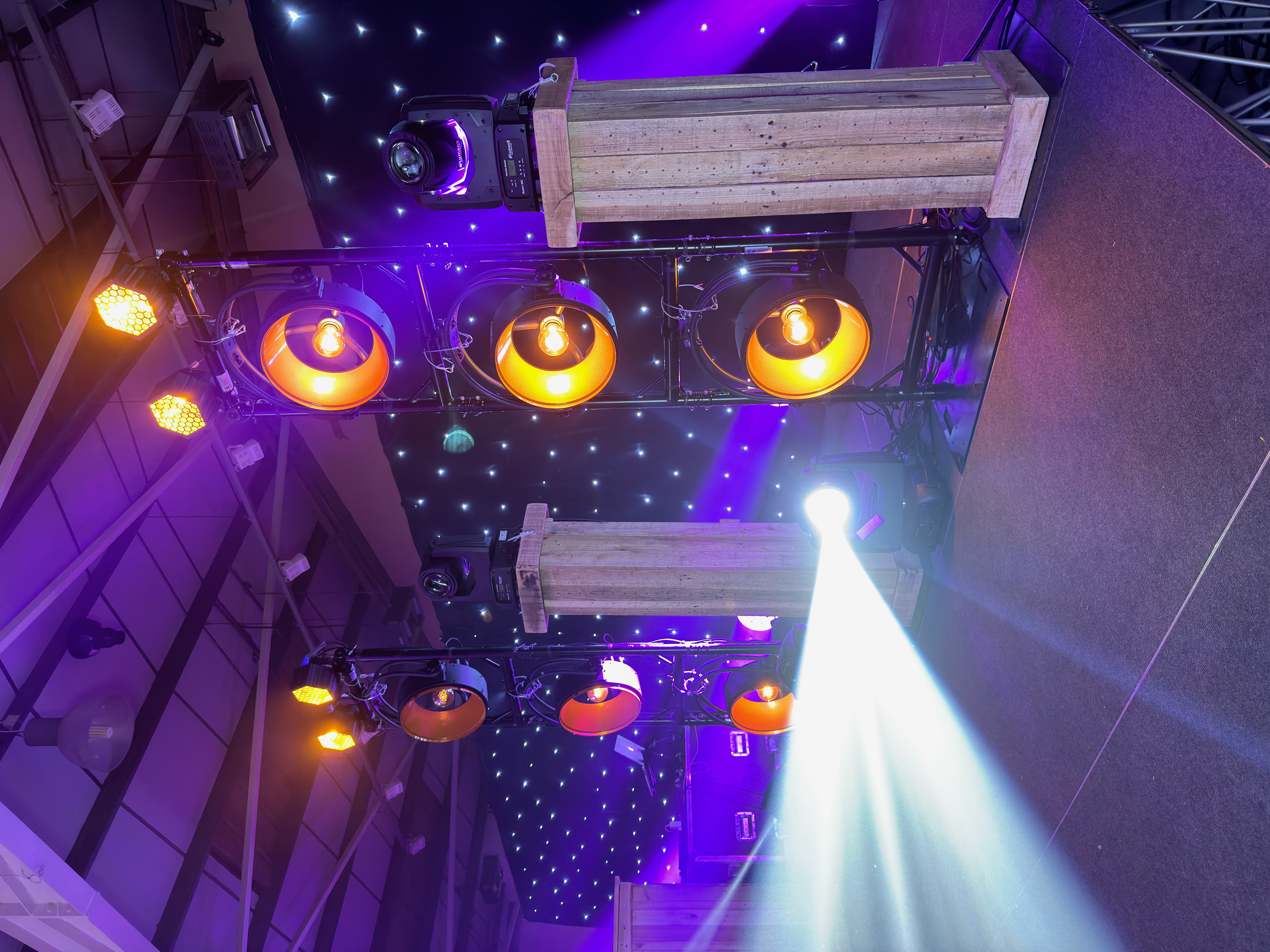 Busfest stage lighting setup at Malvern Showground with warm lamps, moving beams and starlight backdrop