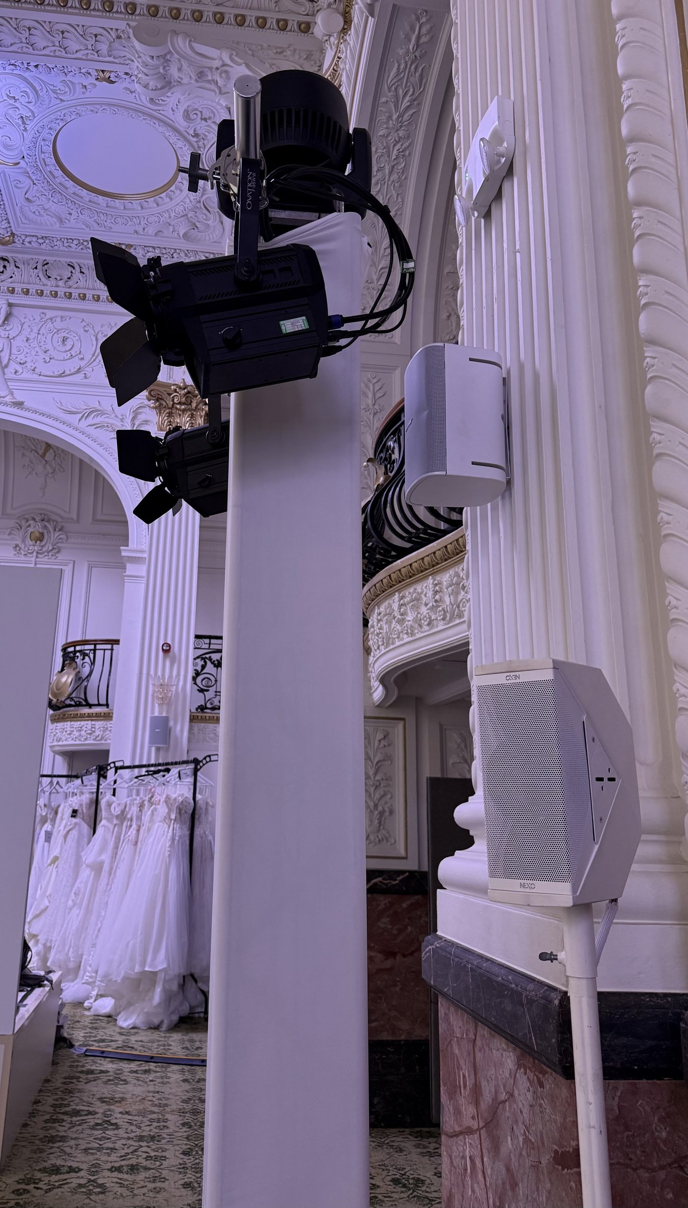 Close view of moving head and spot lighting mounted on a white truss support tower for a fashion show