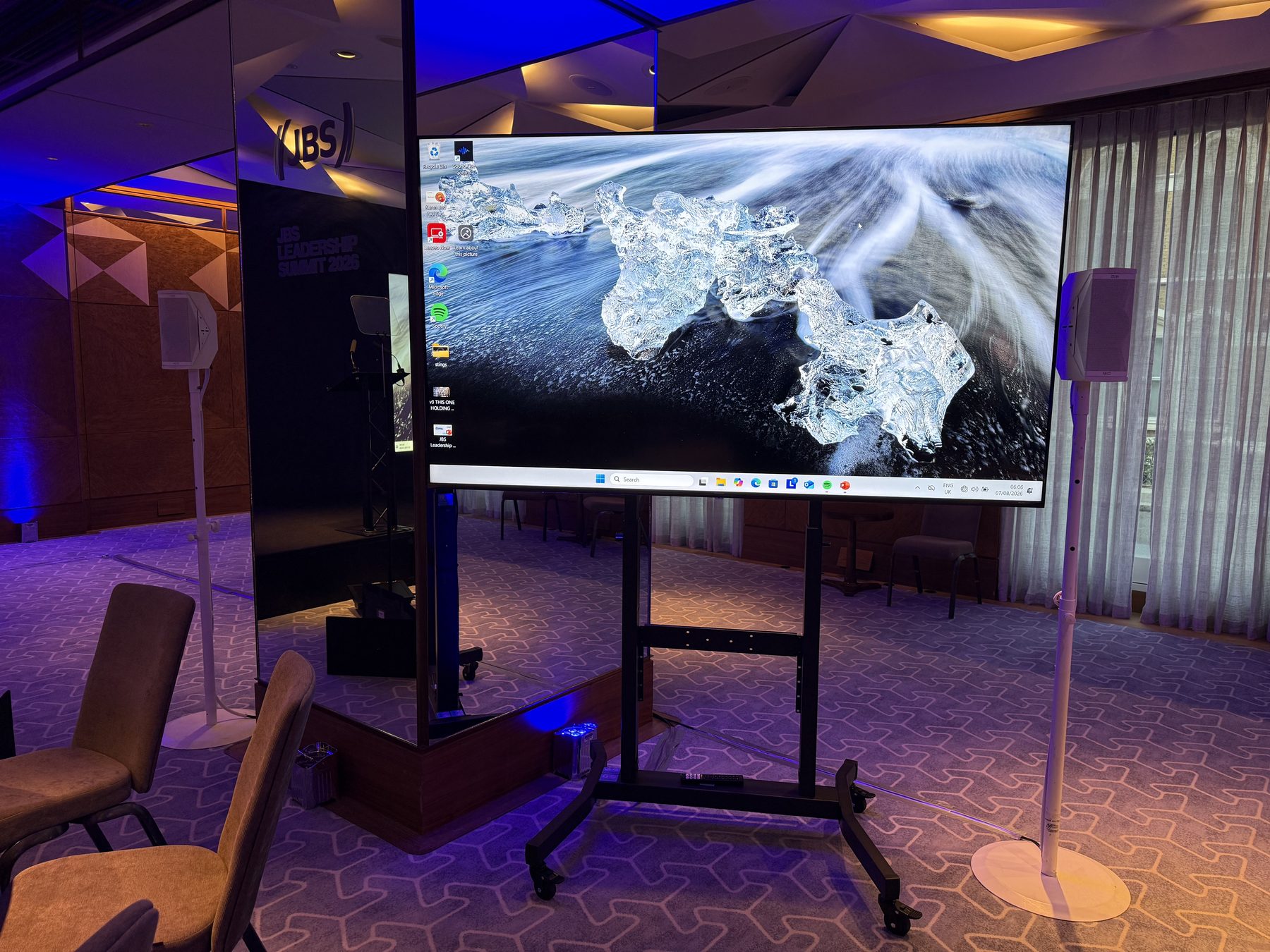 Close view of conference hire screen, speaker and blue uplighting in London
