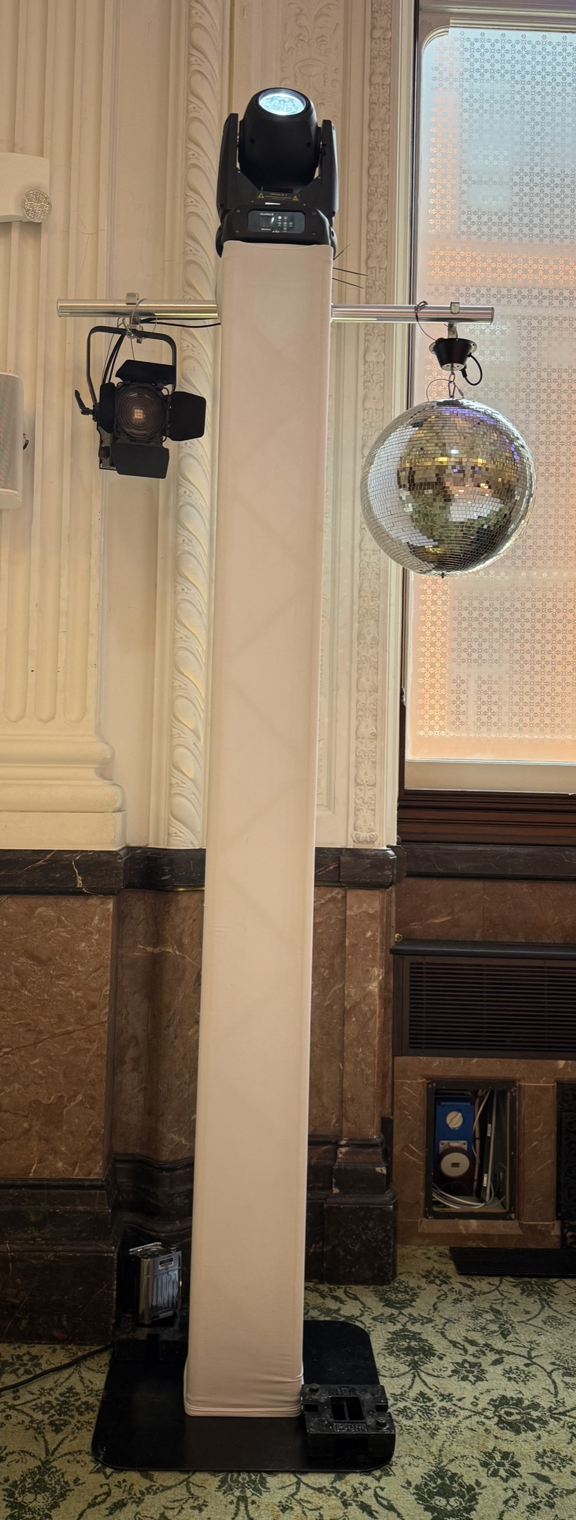 Moving head light and mirror ball mounted on a white lighting tower for a wedding