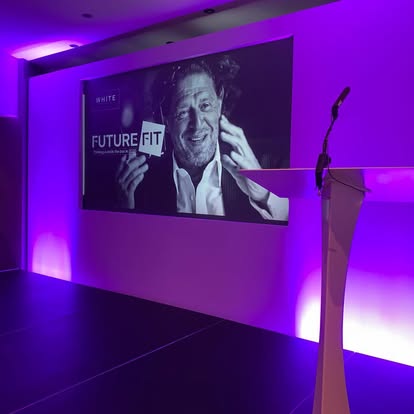 White lectern on a lit presentation stage