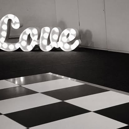 Love illuminated letters beside a black and white dance floor