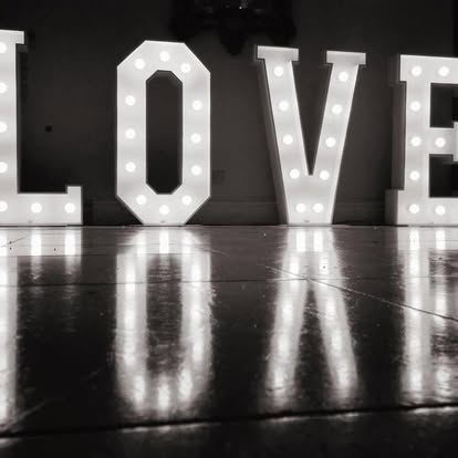 Large illuminated LOVE letters reflected on a floor