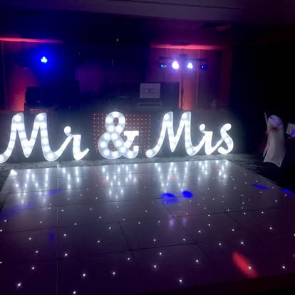Mr and Mrs illuminated letters across a dance floor