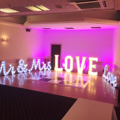Mr and Mrs Love One letters in a pink lit venue