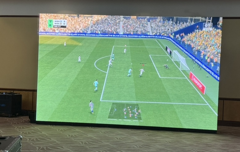 Large LED video wall showing a football game at an event