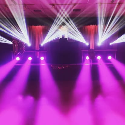Pink lighting effects around a DJ setup