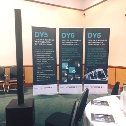 Compact column speaker beside business banners