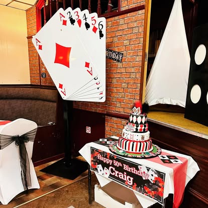 Large diamond playing card prop beside celebration table