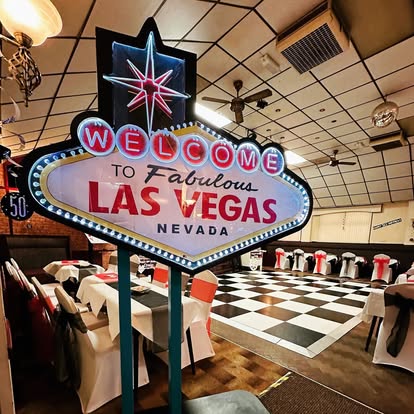Las Vegas sign prop beside a black and white dance floor