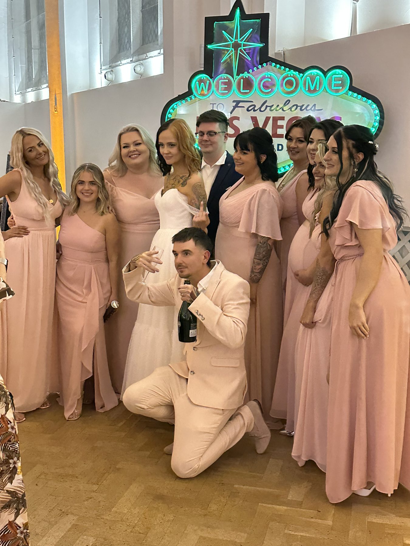 Guests posing beside a Las Vegas sign prop at a celebration