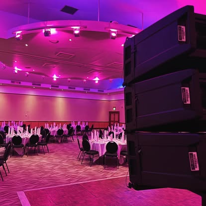 Line array system in a pink-lit venue