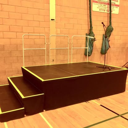 Compact black stage with steps and microphone