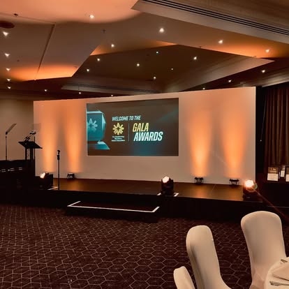 Awards presentation stage with lit wall set