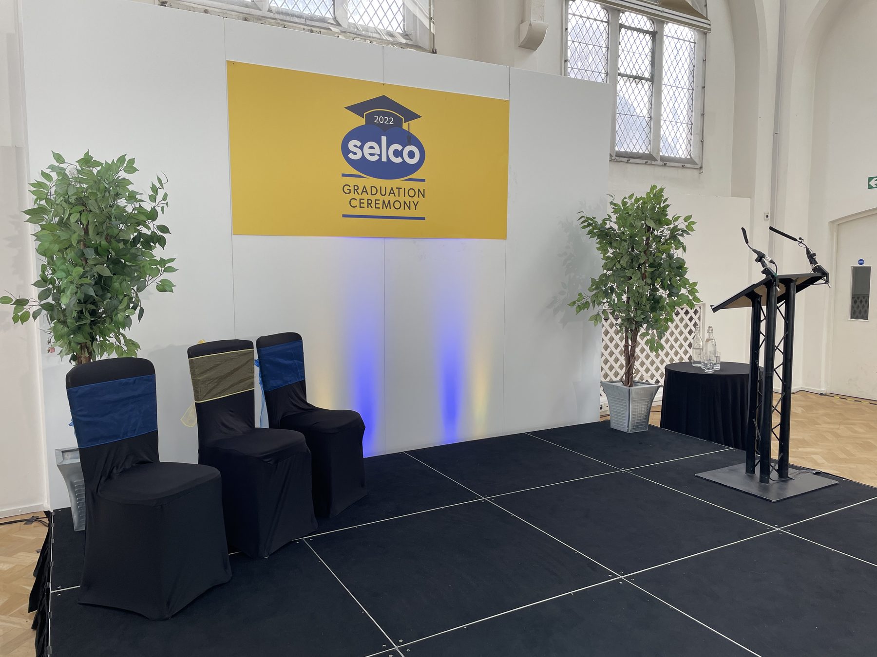 Graduation ceremony stage in Birmingham with lectern, seating and branded backdrop