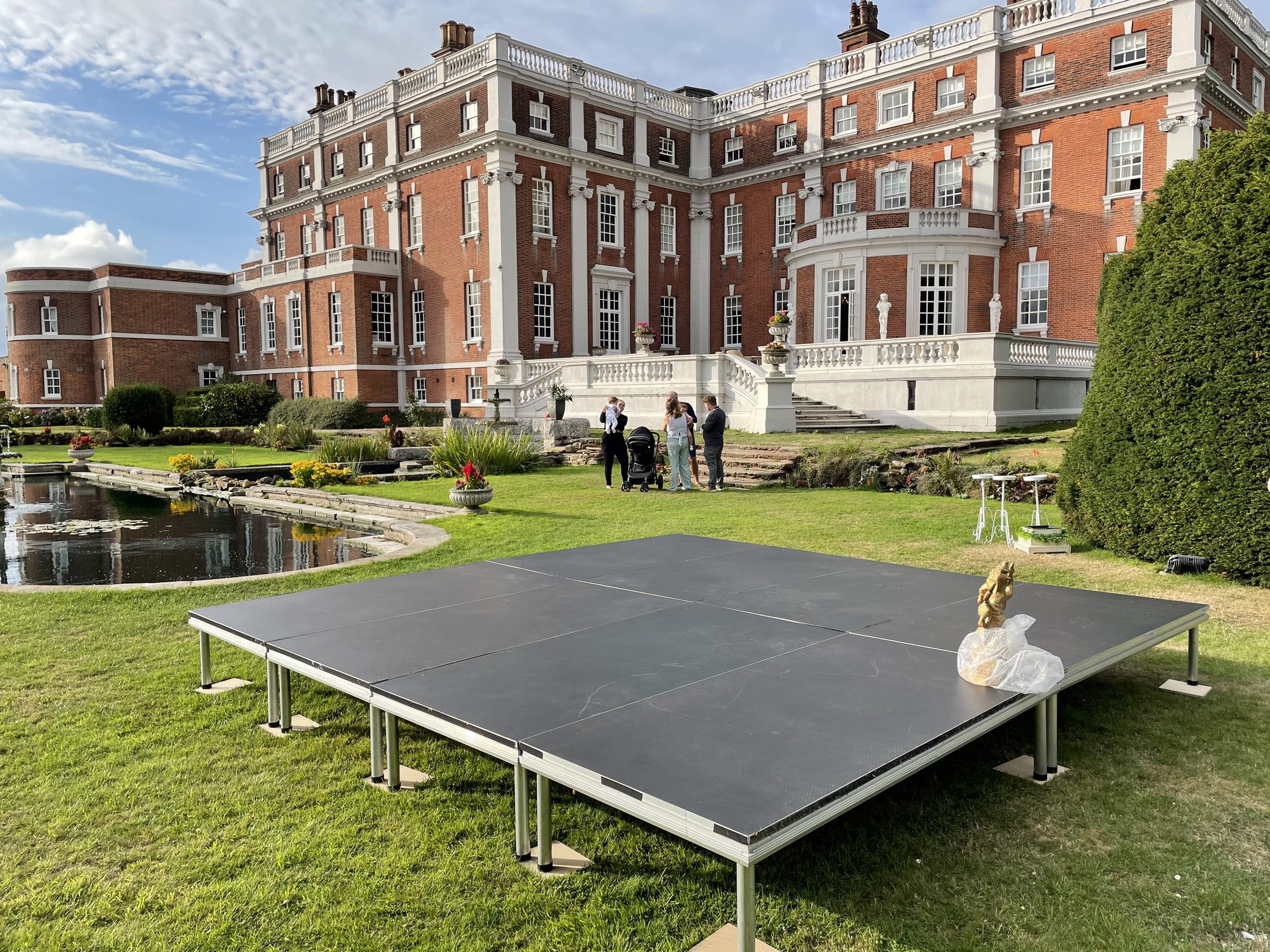 Outdoor modular stage on a lawn at a formal venue