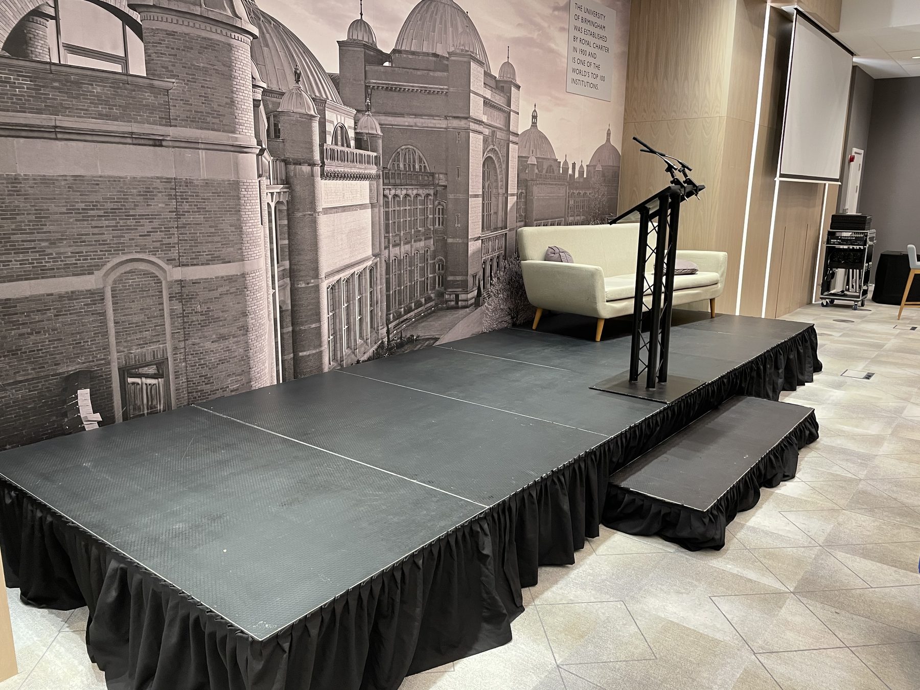 University presentation stage with lectern, microphones, sofa and stage steps in Birmingham