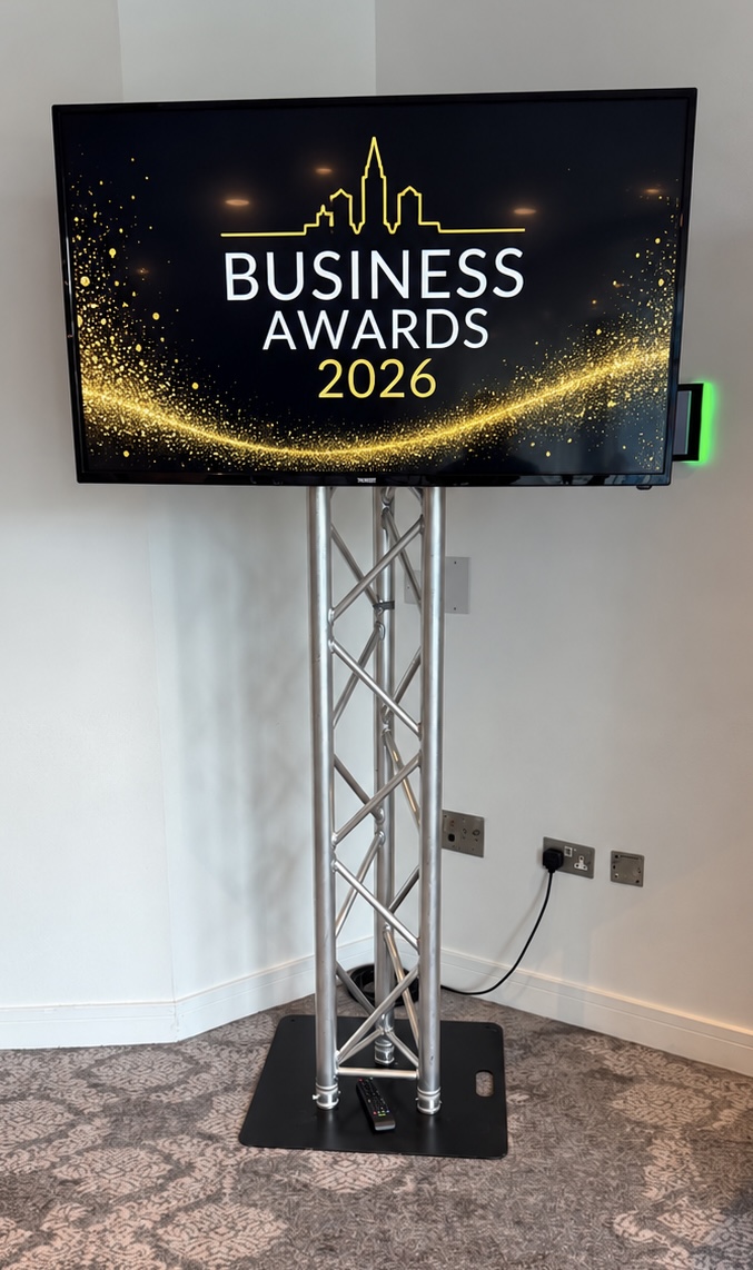TV screen on a silver truss stand displaying Business Awards 2026 branding