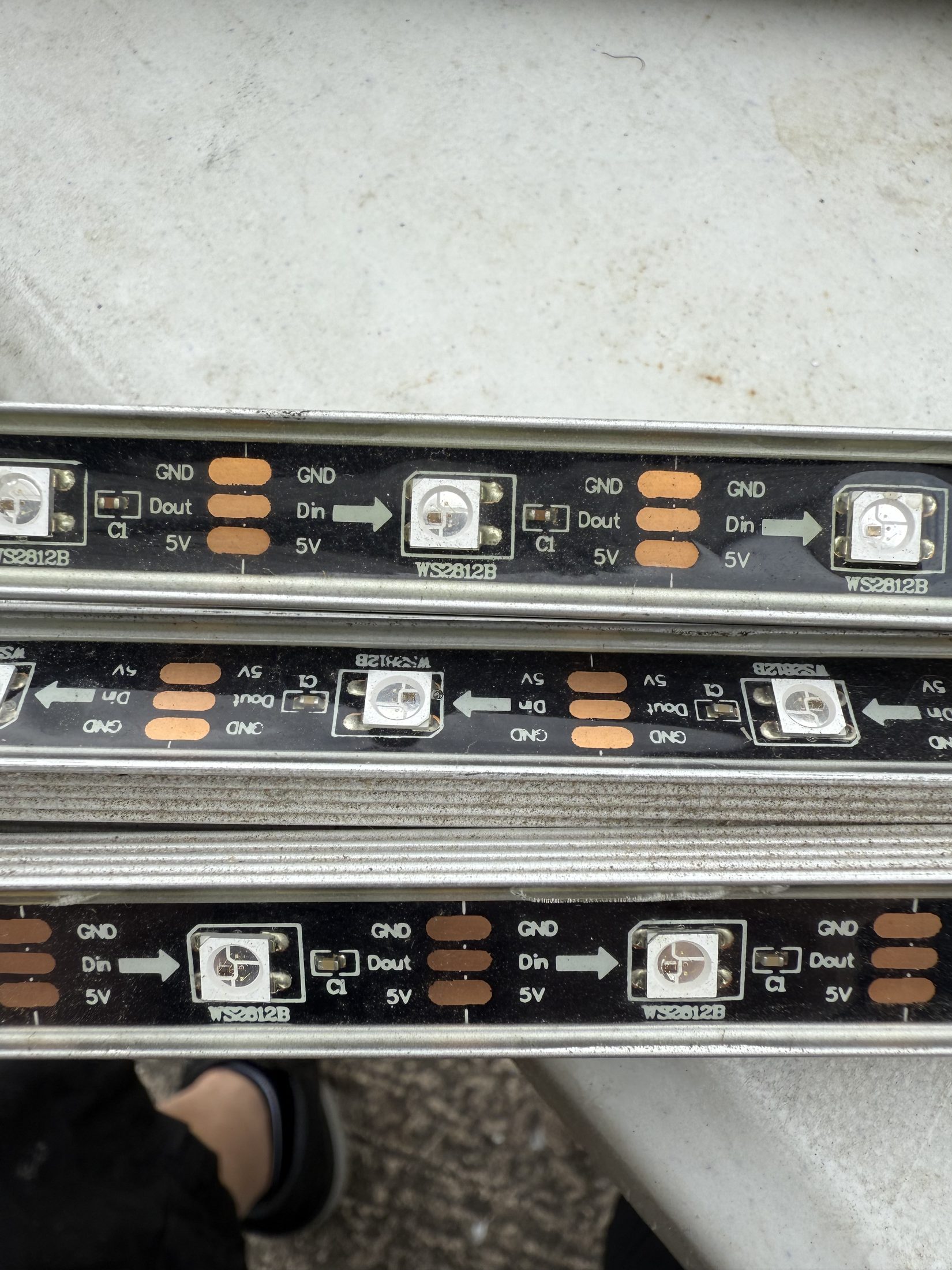 Close-up of WS2812B style addressable RGB LEDs marked 5V, data in and data out