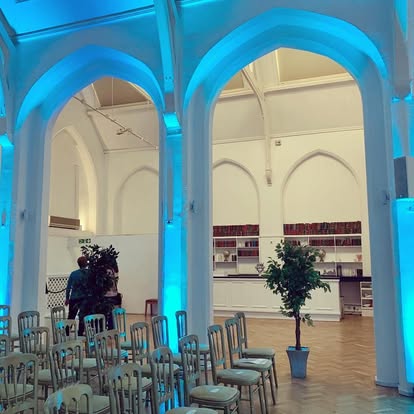 Blue uplighting on arches in a venue