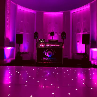 Pink wall wash behind DJ and dance floor