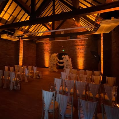 Warm amber wall washing in a barn venue