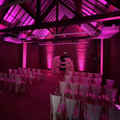 Pink wall washing in a rustic wedding venue