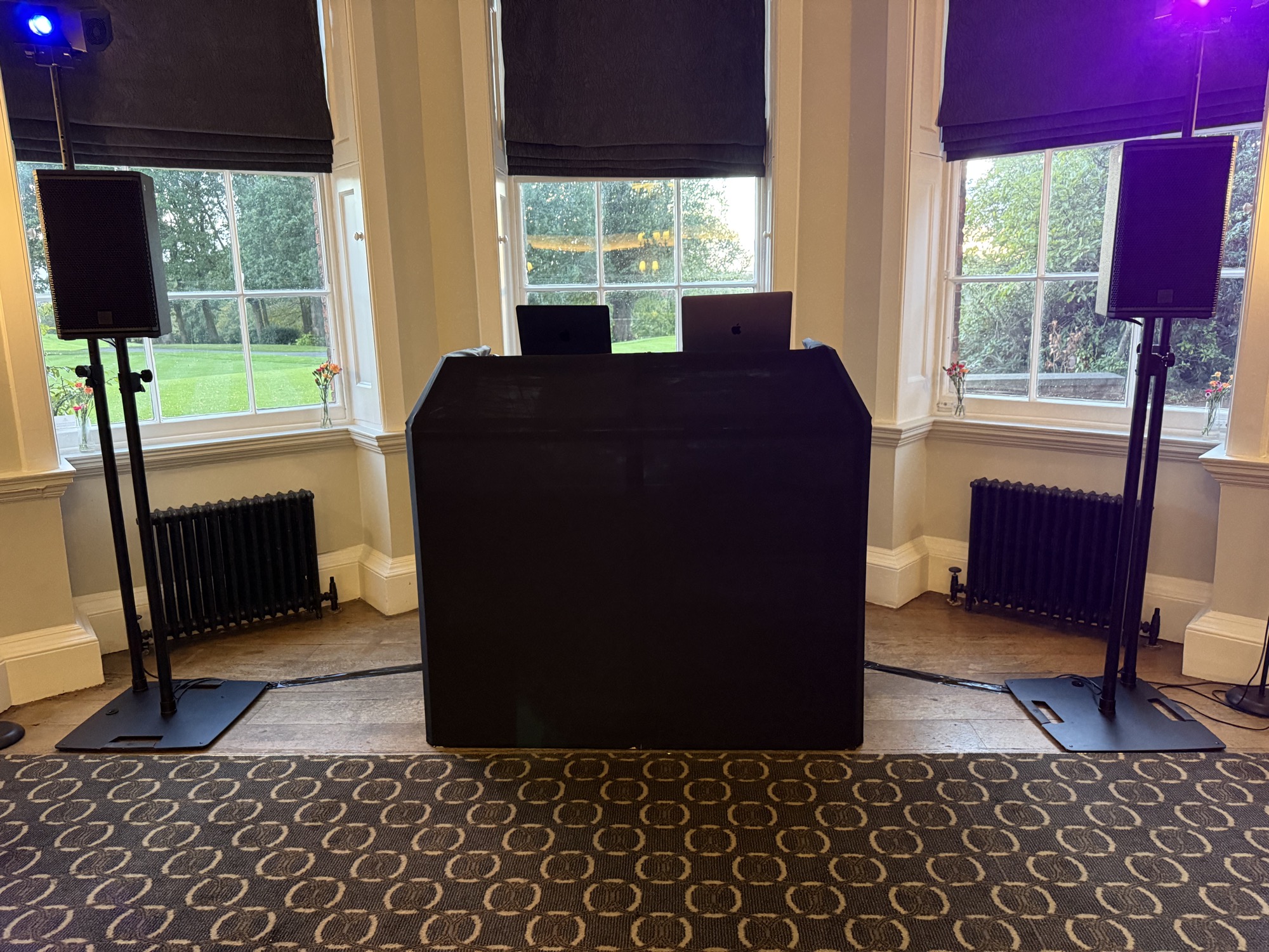Compact disco setup supplied at Edgbaston Golf Club with a black DJ booth, two speakers and coloured lighting